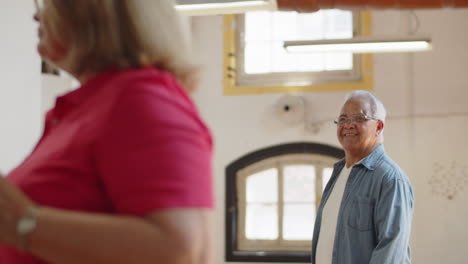 plano medio de un lindo anciano bailando en un salón de baile con su esposa