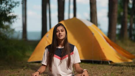 young woman camping in the forest