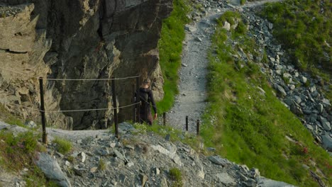 a man is walking on ghiacciaio fellaria hike trails in valmalenco, italy