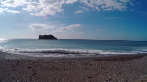 Un-Día-Tranquilo-En-Una-Playa-Griega,-Con-Una-Vista-Panorámica-Del-Mar-Y-Formación-Rocosa