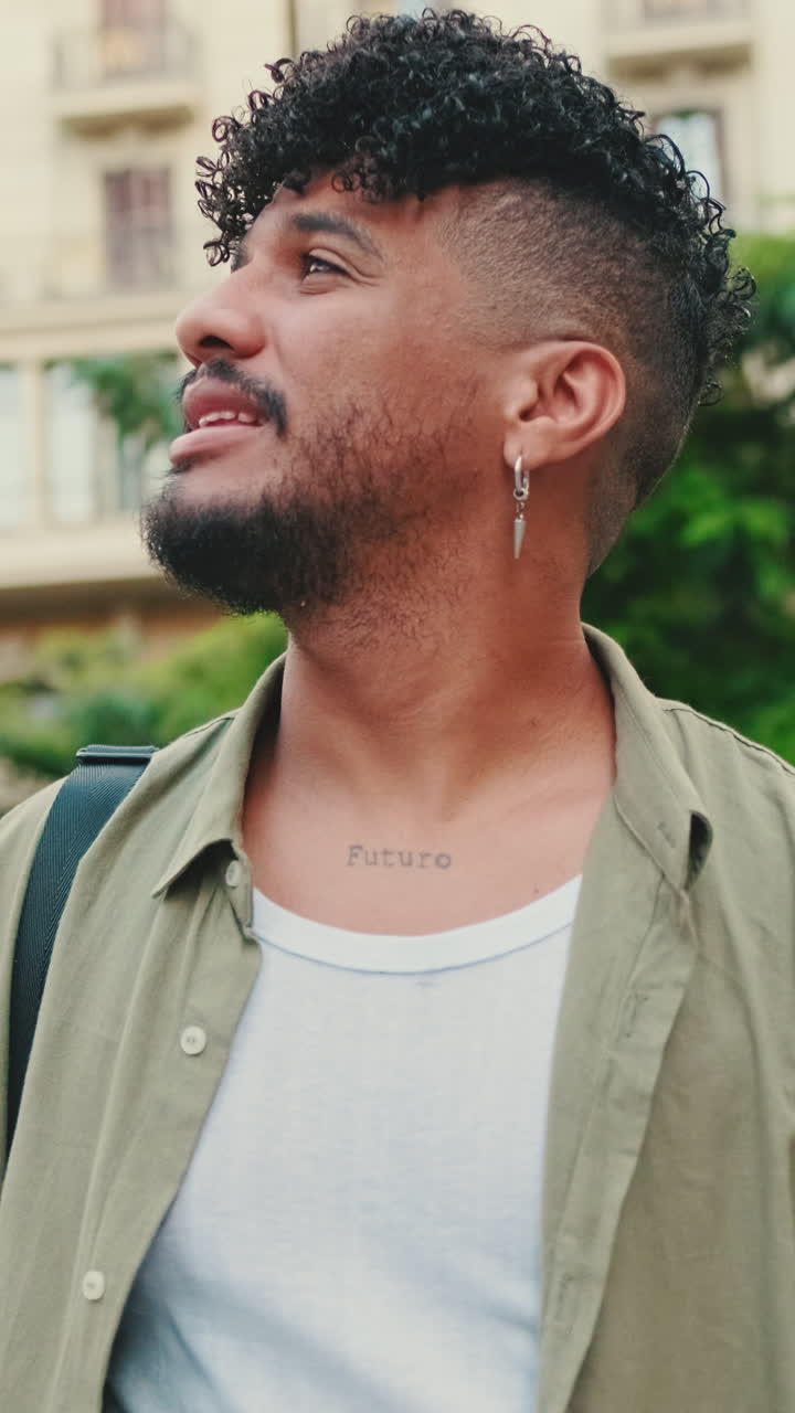 Man with curly hair and tattoo
