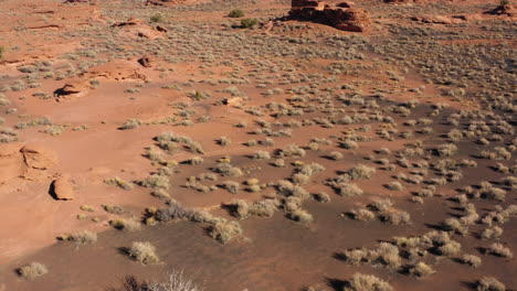 establishing reveal shot as drone flies over the wukoki pueblo ruins surrounded by inhospitable area