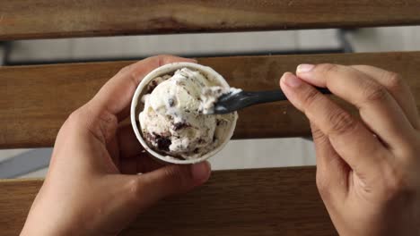 Women-hand-eating-vanila-flavor-ice-cream-in-a-container-,