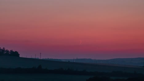 Luna-Creciente-Establece-Lapso-De-Tiempo-Con-Cielo-Naranja-Y-Fuegos-Artificiales-Cortos-En-El-Horizonte,-Menos-Alrededores