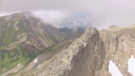 hiker on a rocky mountain ridge with cloud-covered valley