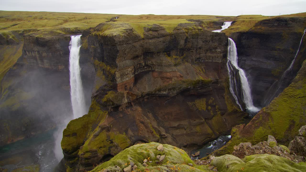 una foto amplia en un acantilado de una alta cascada en islandia