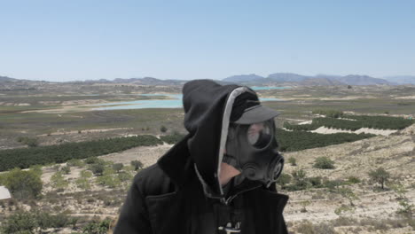 a man in a gas mask wanders through the post apocalyptic desert wasteland