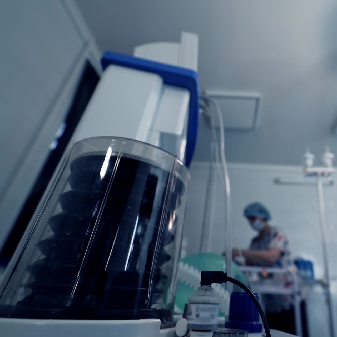 Work of ventilation equipment. Modern medical device for artificial lung ventilation on the background of medical team in operating theater. Saving patient's life.