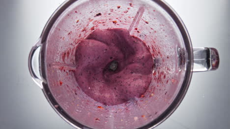 fresh berry cocktail mixing in blender close up top view. blending smoothie.