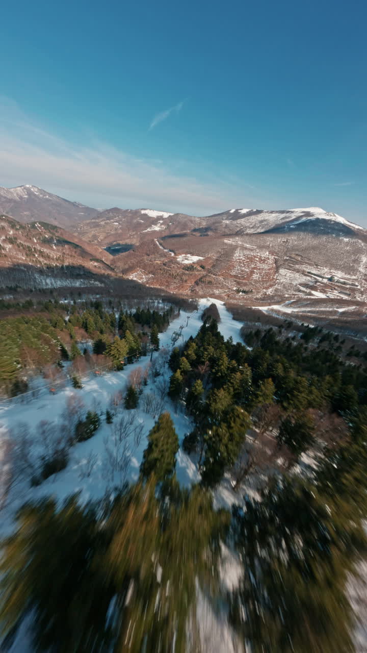 Drone FPV che vola su una montagna innevata con cielo azzurro limpido