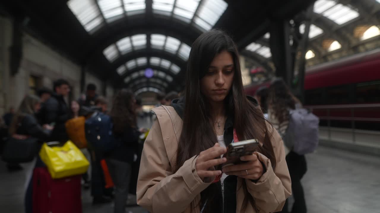 mujer usando el teléfono en la estación de tren