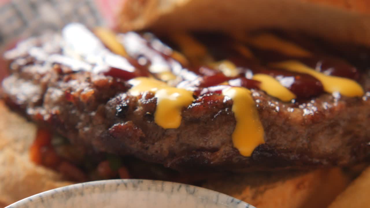 Primo piano di un succulento hamburger con senape e salsa
