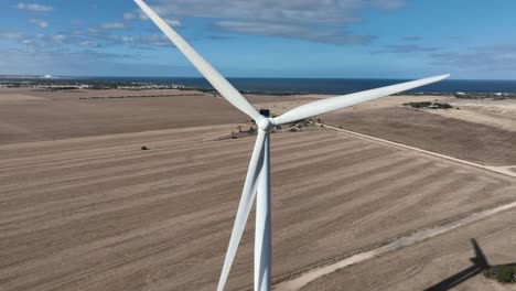 tracking drone shot of spinning wind turbine