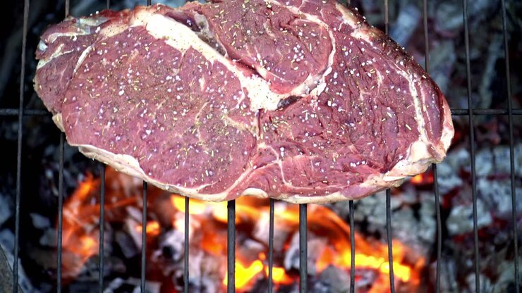 Steak sapi dimasak di atas panggangan.