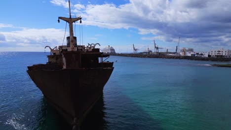 Hermosa-Vista-Aérea-Vuelo-Barco-Proa-Naufragio-En-La-Playa-Banco-De-Arena-Lanzarote-Islas-Canarias,-Día-Soleado-España-2023