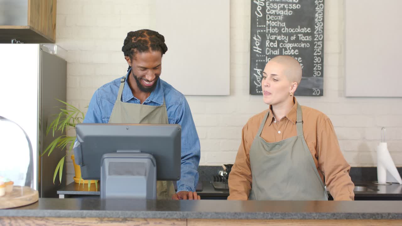 Verschiedene Angestellte tippen auf ein Touchscreen-Terminal, passen die Bestellung an und bearbeiten sie in einem Café