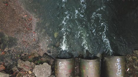 concrete waste pipes. streams of water flow through concrete pipes. polluted body of water in the park. shooting from the drone with the camera down.