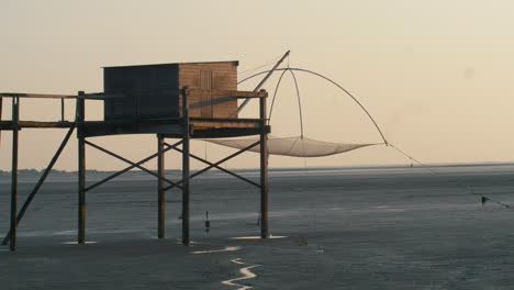 Fisherman's-cabin-hut-carrelet-during-dusk-in-Baie-de-Bourgneuf,-France