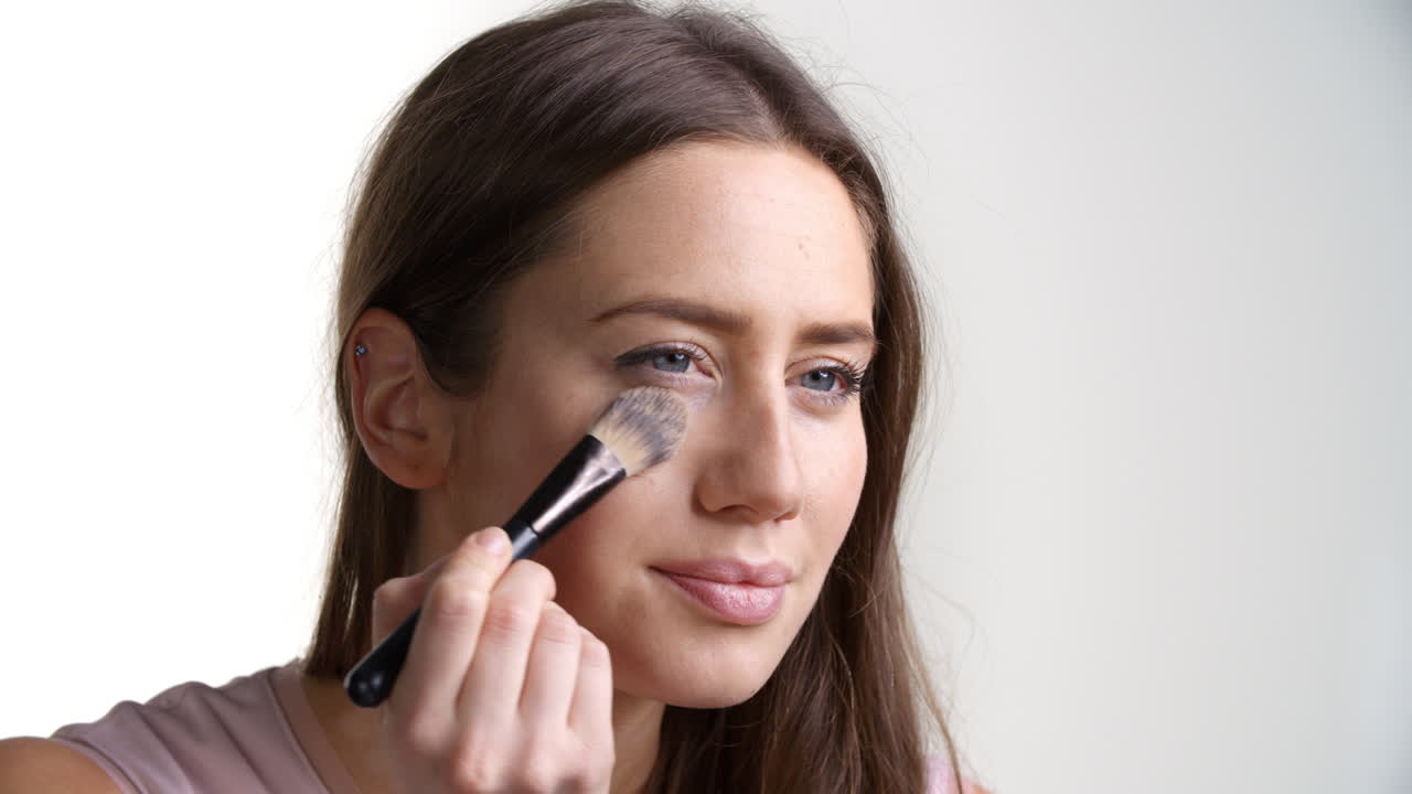 fotografía de estudio de una mujer atractiva usando polvo para la cara