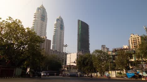 timelapse of a large junction in mumbai with the two imperial towers in the background, afternoon