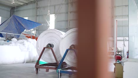 rollos de tela blanca de tamaño industrial en el almacén