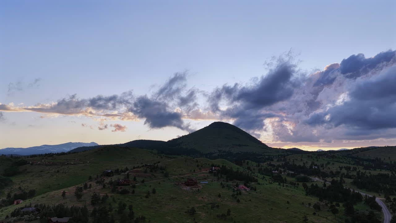 Drone footage of a summer sunset over the mountains near Boulder, Colorado. Aerial view of scenic wilderness, ridges, and forested landscapes.