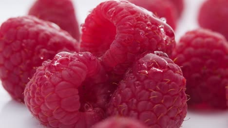 fresh raspberries, water drops falling over small red berries - ultra slow motion close up