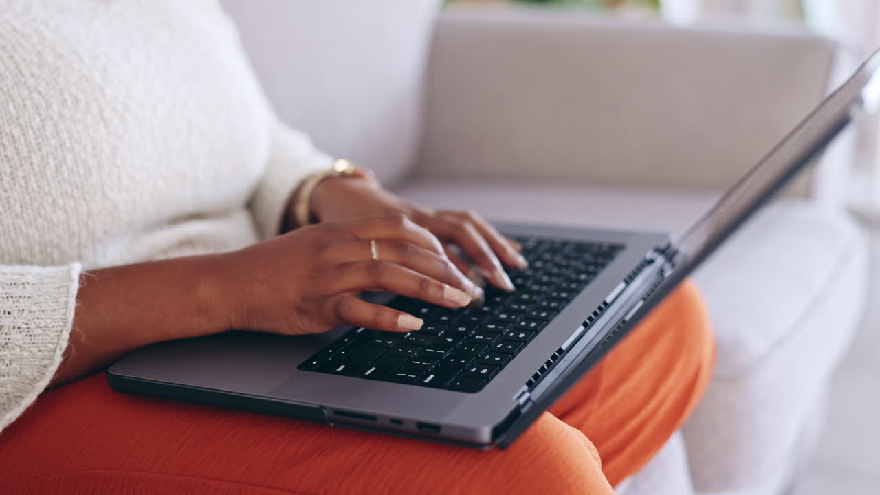 Hands typing, laptop and woman on sofa with work