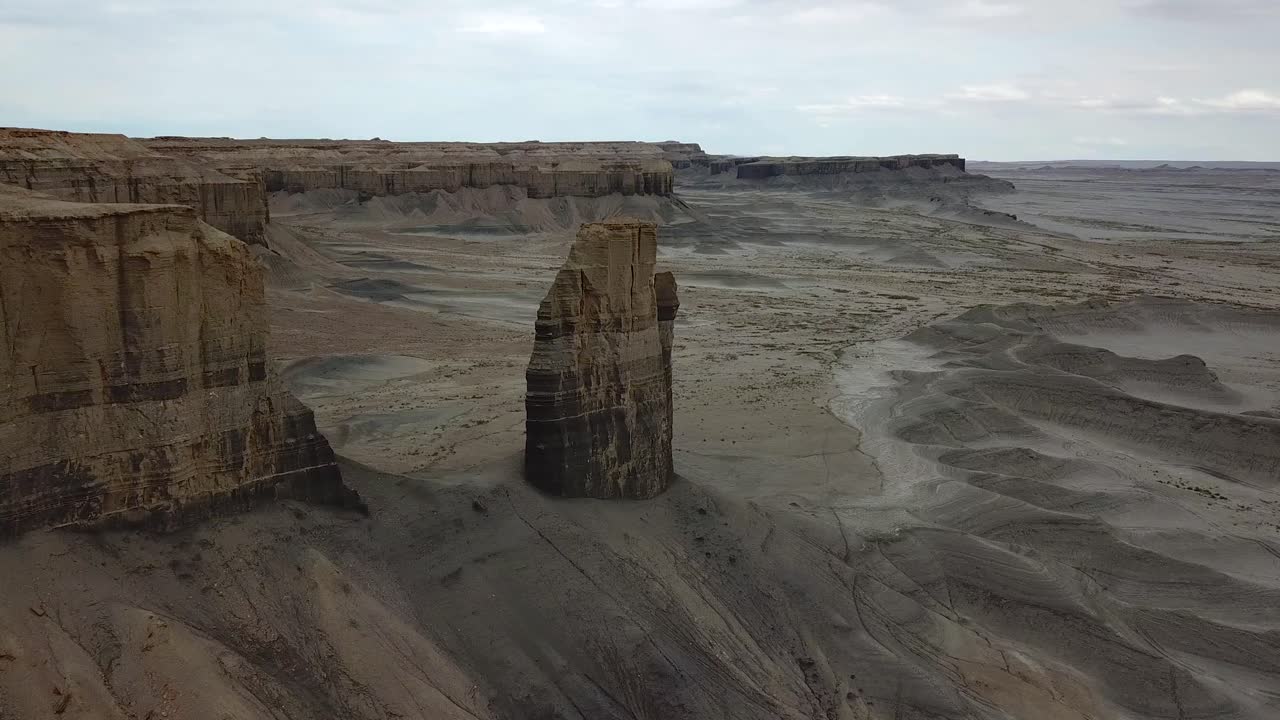 Pull Back Aerial View of Butte Rock Formation in Dry Landscape of Utah Desert