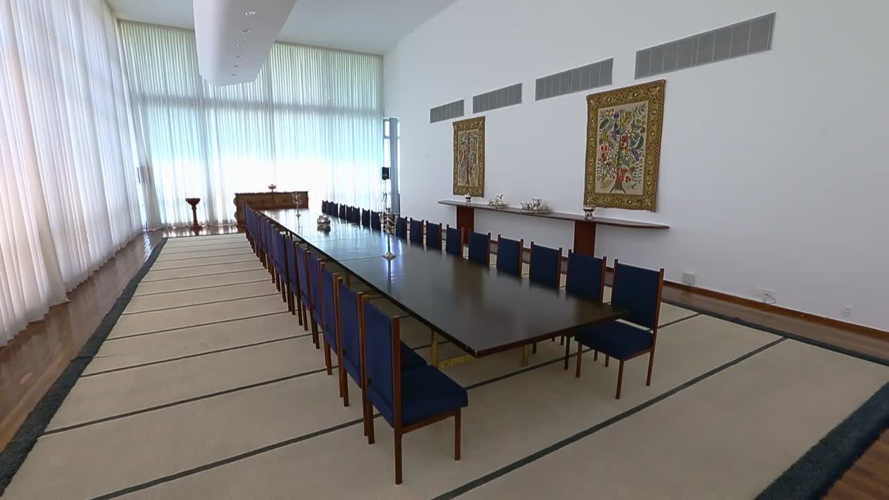 A grand formal dining or meeting room with a long table and chairs