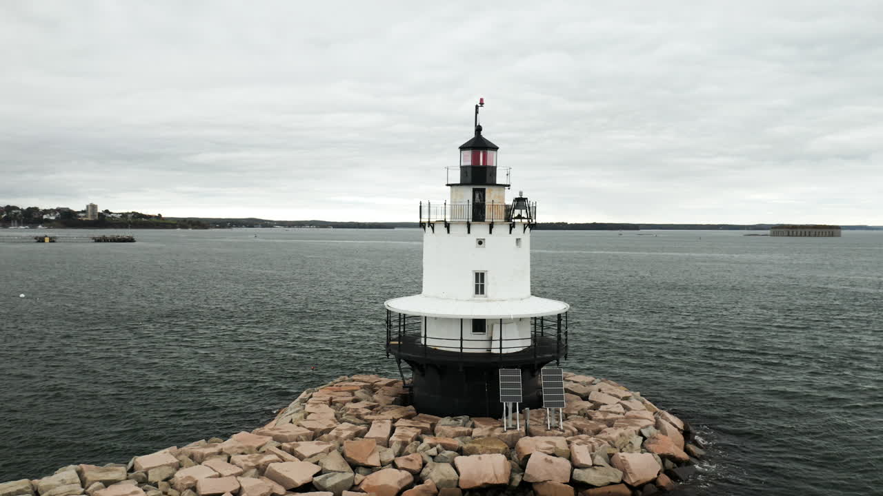 magnífica toma aérea oscilante del faro de la cornisa de spring point en maine, fort gorges en el fondo