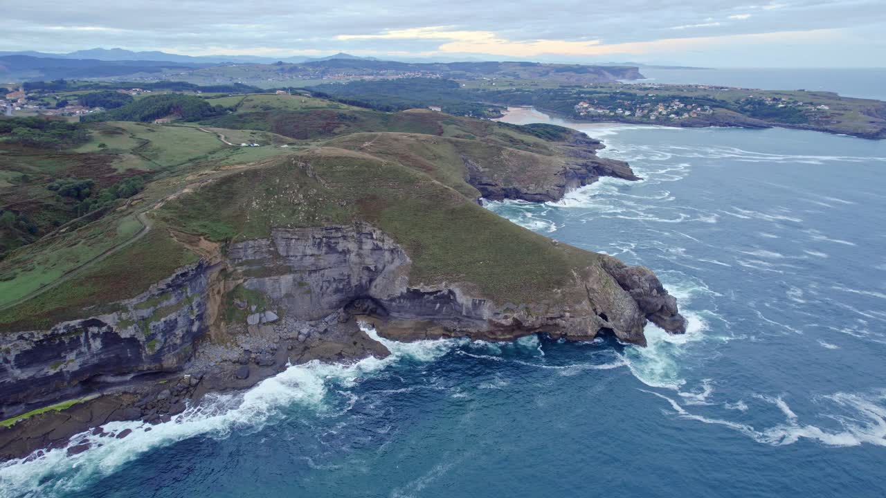 дрон снимает зеленый пейзаж острова вместе с синим цветом кантабрийского моря с большой высоты.