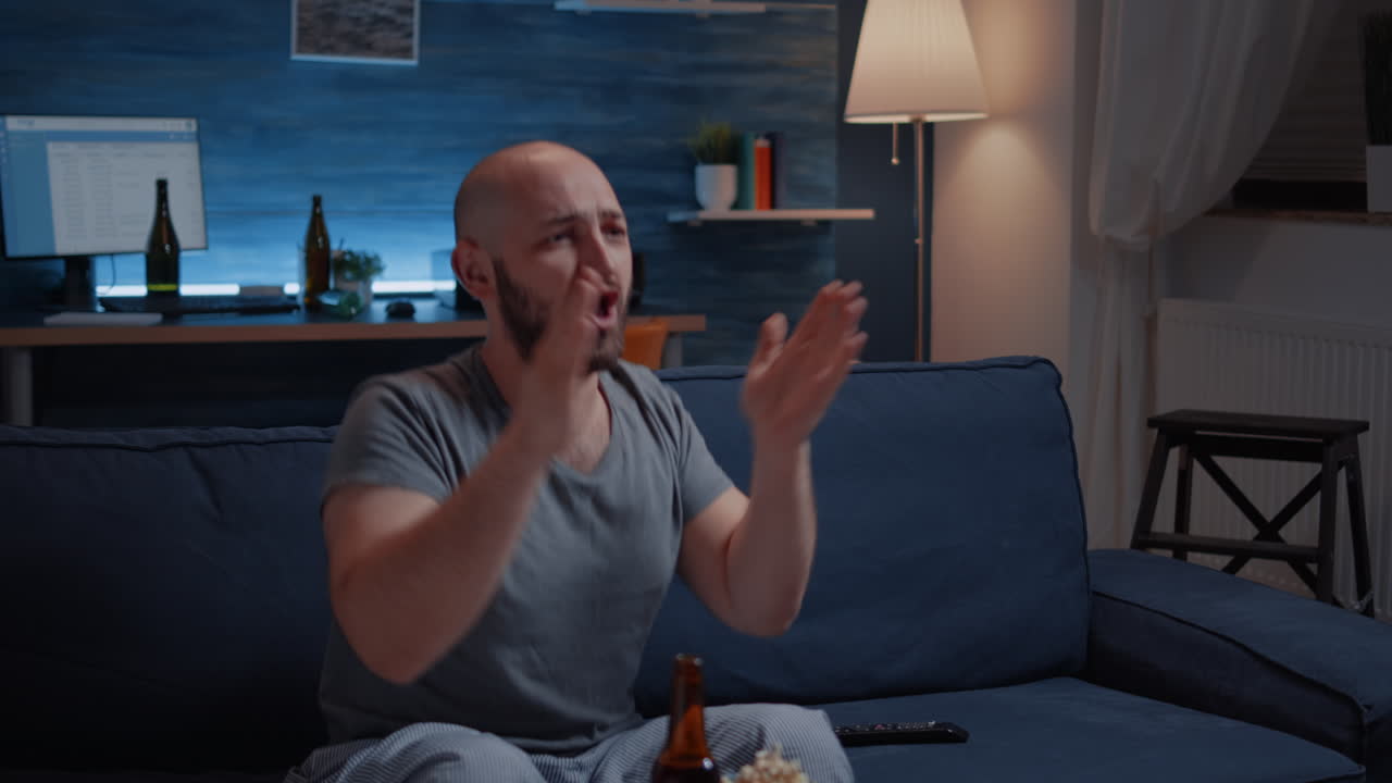 Football fan watching sport game supporting team raising hands after winning