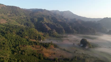 the beautiful forest in thailand composed of green trees and cloudy blue sky above - aerial shot