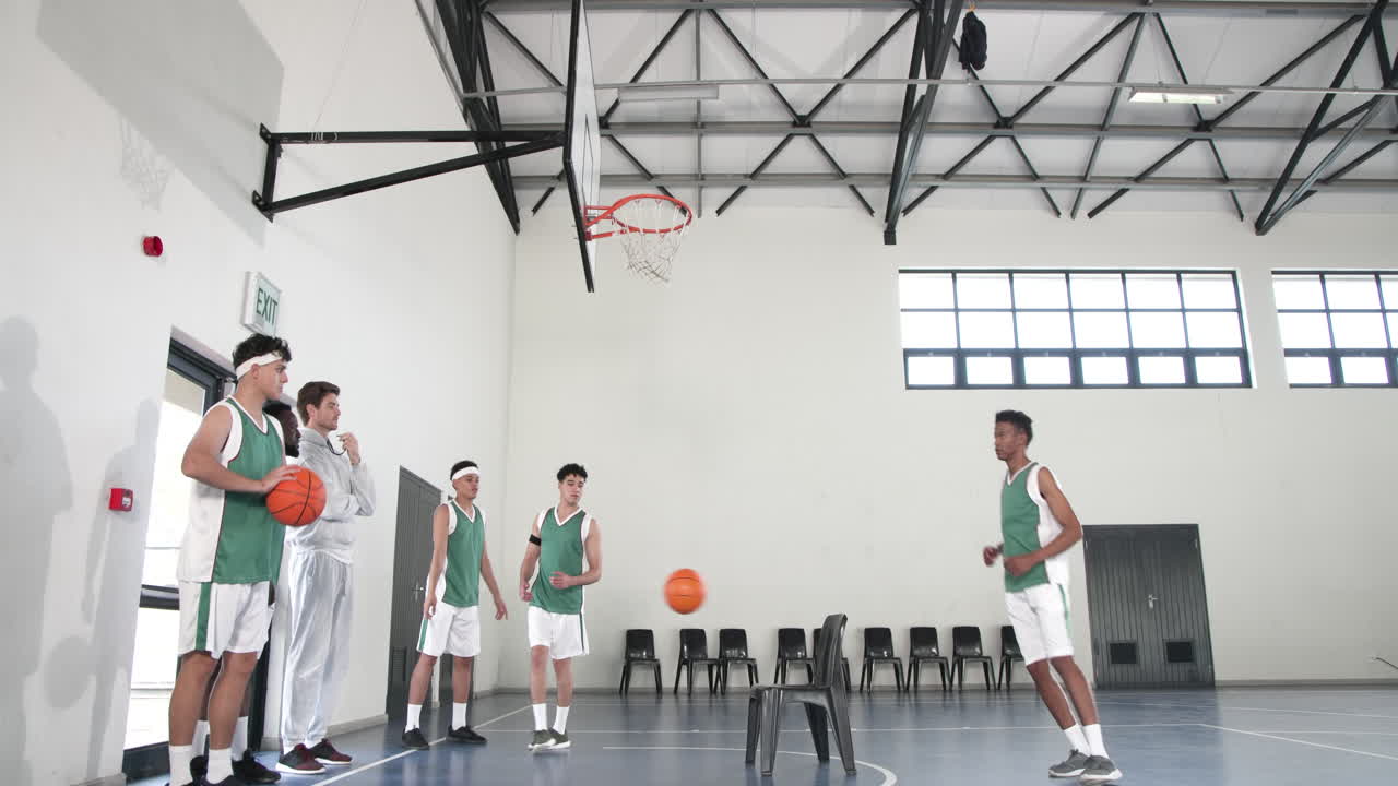 Basketball players practicing shooting skills in gym, focusing on teamwork