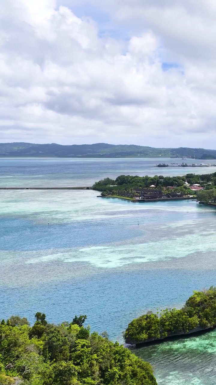 Inquadratura aerea dall'alto di lussureggianti isole carsiche verdi circondate da limpide acque turchesi del Pacifico.