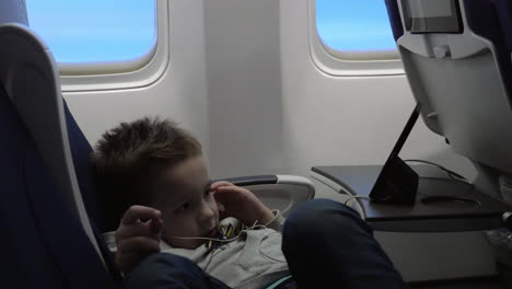 niño entretenido con teléfono móvil en el avión