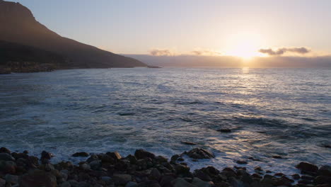 relajante vista de la puesta de sol desde la playa con olas del océano