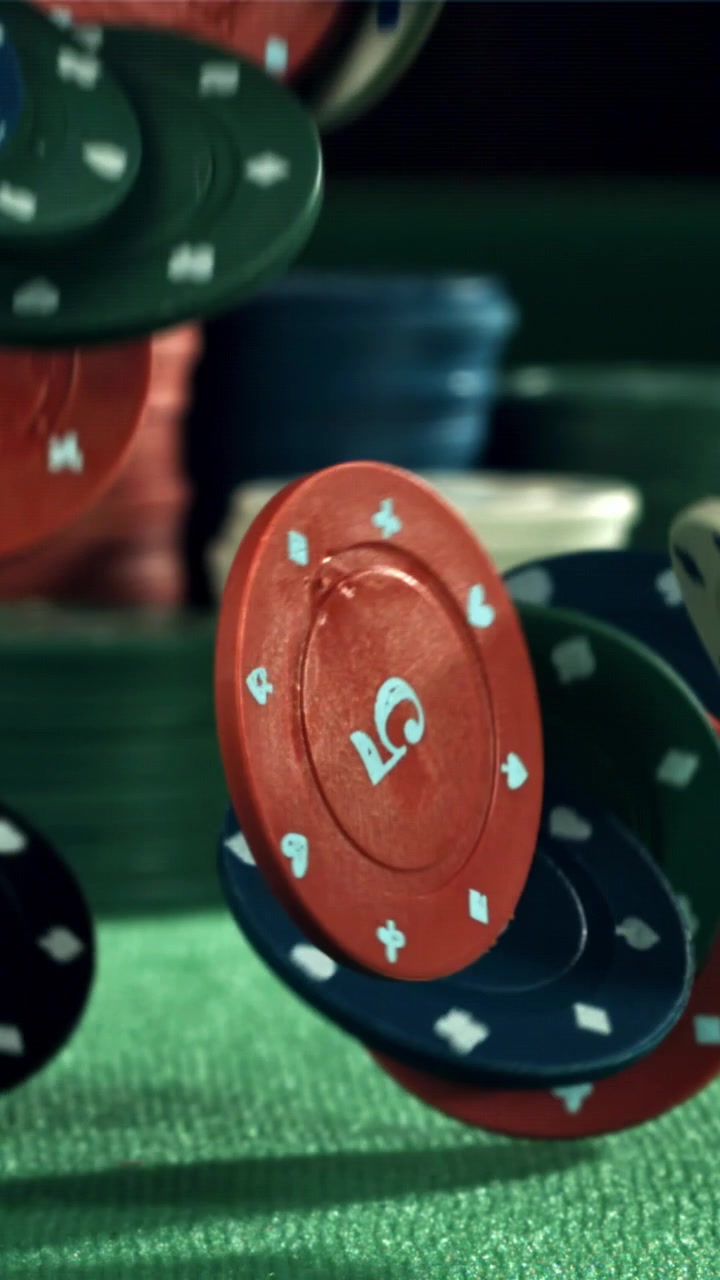 Fiches da poker colorate che cadono e rimbalzano su un tavolo di feltro verde