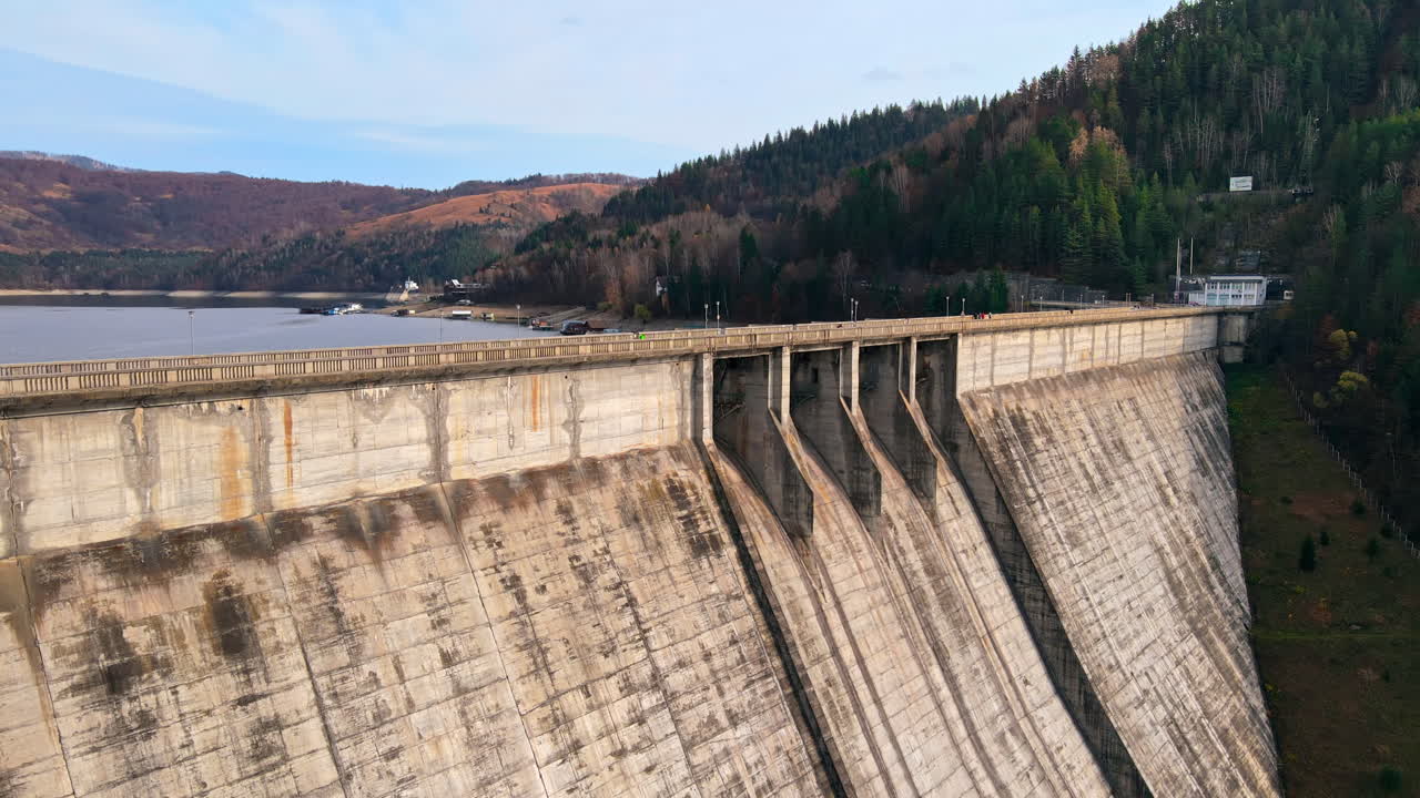 Aerial drone view of Bicaz lake and dam with cars in Romania. Hills covered with lush forest