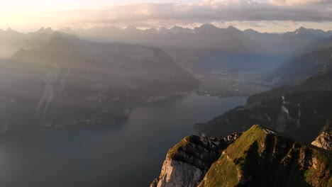 Vista-Aérea-Junto-A-Los-Acantilados-De-Niederbauen-Chulm-En-Uri,-Suiza,-Con-Vistas-Al-Lago-De-Lucerna-Y-Sus-Fiordos-En-Una-Mañana-Dorada-De-Verano-En-Los-Alpes-Suizos