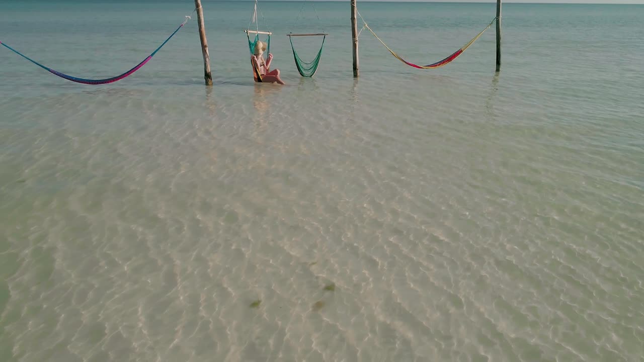 mujer disfrutando del sol refrescante mientras se sienta en una silla giratoria durante las vacaciones