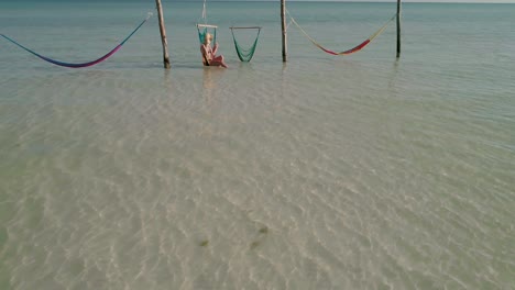 Woman-enjoying-refreshing-sunshine-while-sitting-in-swing-chair-during-vacation