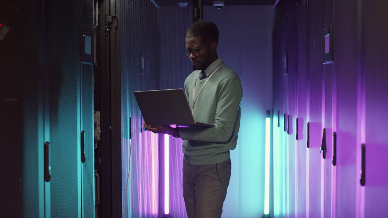 IT Specialist Analyzing Work of Data Center Using Laptop