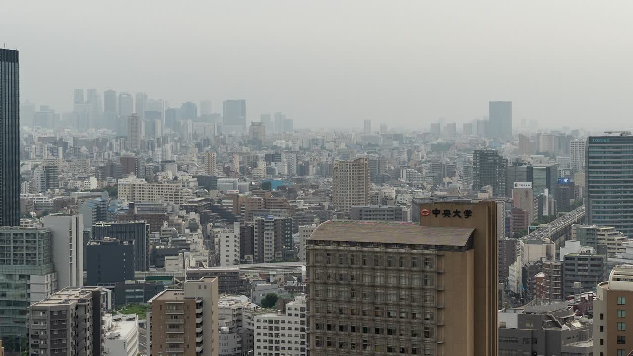 panorámica derecha rápida sobre el horizonte de tokio en un día gris y brumoso con tráfico de automóviles