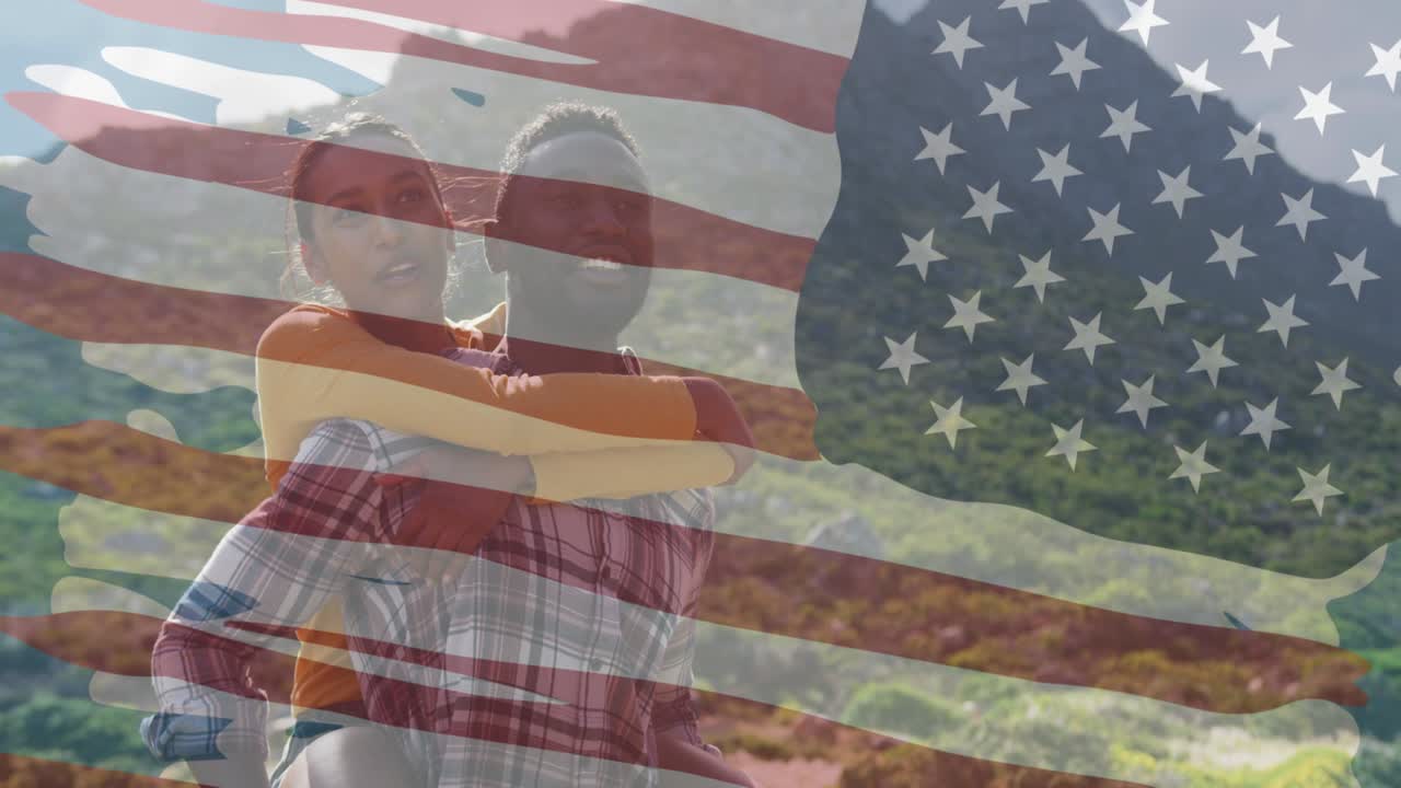 animación de la bandera estadounidense sobre una pareja diversa sonriente abrazándose en las montañas