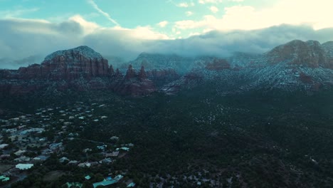 vista aérea de sedona durante el invierno con colinas de arenisca cubiertas por niebla y nubes al amanecer.