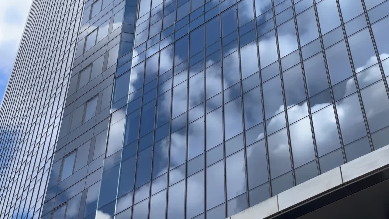 Nubes reflejándose en las ventanas de un moderno rascacielos de cristal