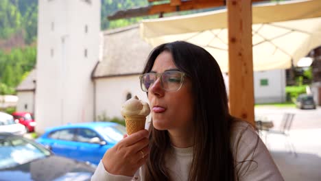 closeup portrait of woman enjoying eating ice cream in italian exterior bar