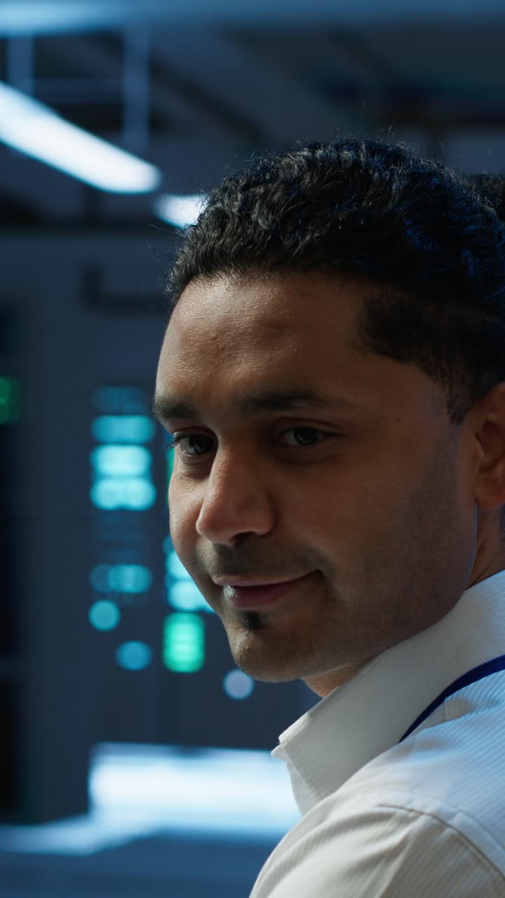 IT Professional Typing on Keyboard and Smiling at Camera
